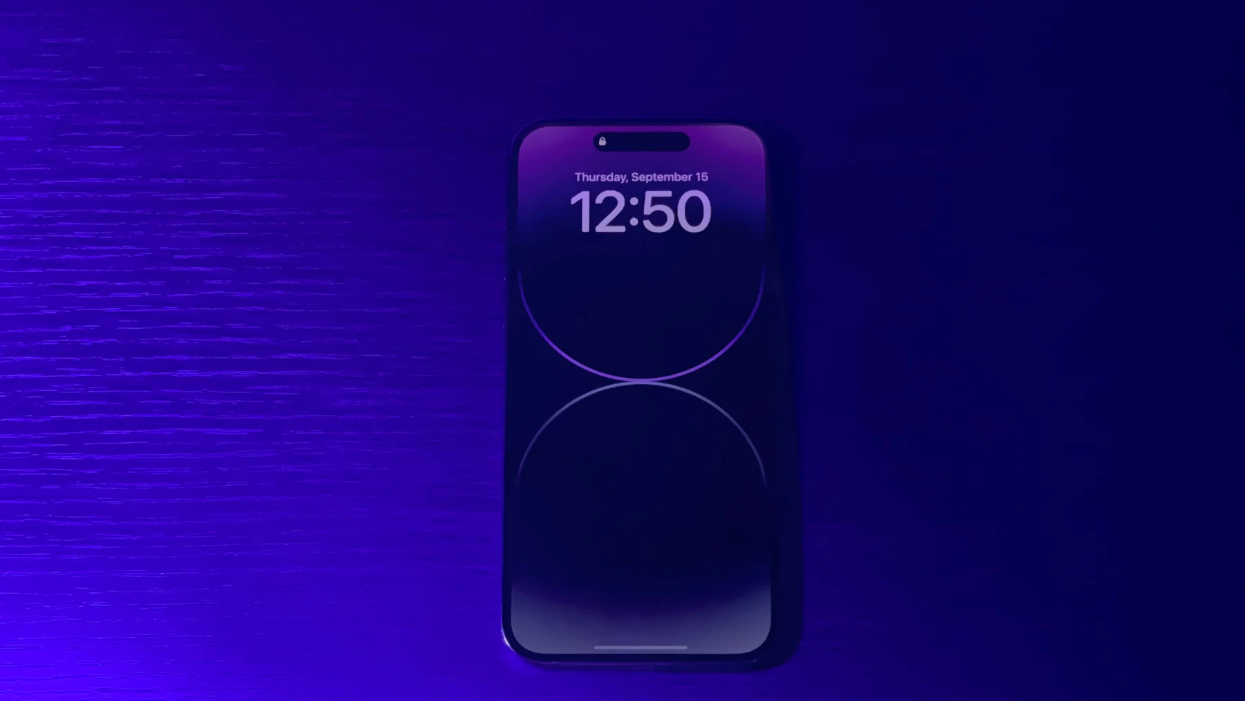iPhone 14 Pro with a purple Always-On Lock Screen against a purple event backdrop